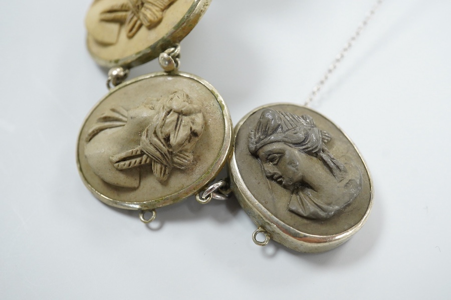 A Victorian base metal bracelet, set with seven graduated lava cameos, carved with the busts of lady's to dexter and sinister, approximately 16.5cm.